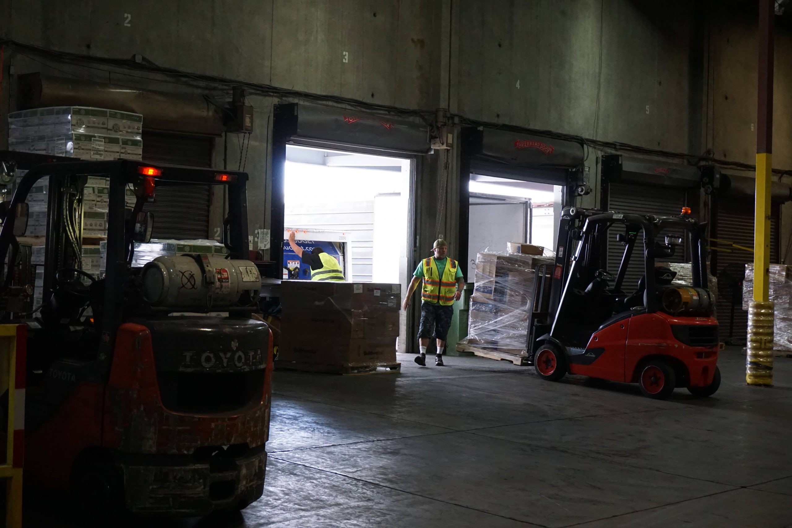 Forklift handling materials in a logistics facility with specialized equipment
